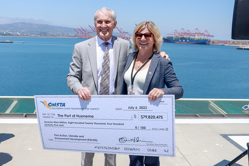 Asm. Bennett and official holding large ceremonial check