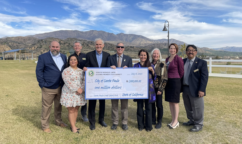 Asm. Bennett and others holding large ceremonial check