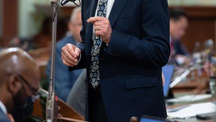 Asm. Bennett standing at microphone, speaking on the Assembly Floor
