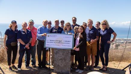 Group photo with large ceremonial check held at center