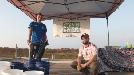 Coastal Keepers booth staffers posing with buckets and trash pickers