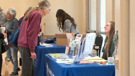 Constituent conversing with staffer at informational booth