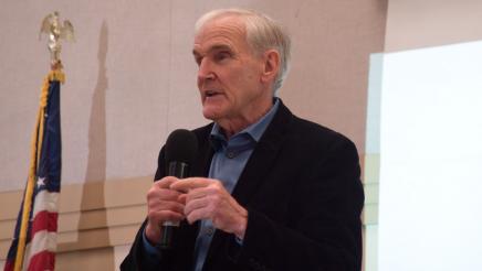 Asm. Bennett holding microphone, speaking