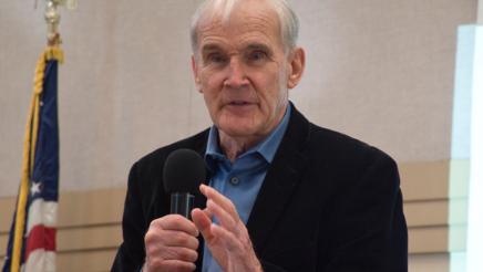 Asm. Bennett holding microphone, speaking