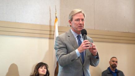Guest speaker holding microphone, speaking