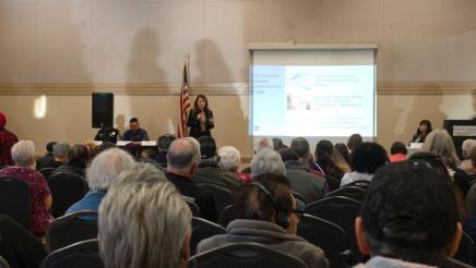 Guest speaker at head of room, speaking to audience