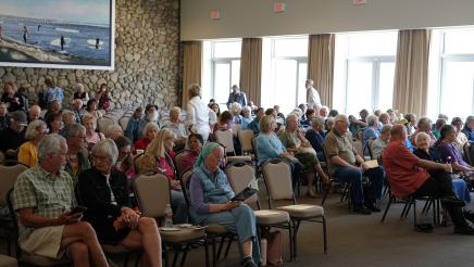 Attendees begin to sit down at the beginning of the event.
