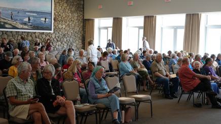 Attendees begin to sit down at the beginning of the event.