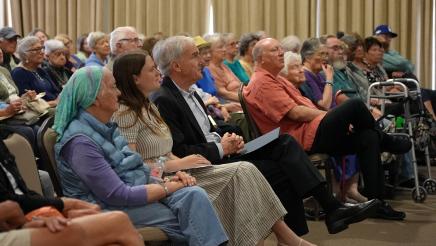 Asm. Bennett (center) seated next to Office Assistant Taylor Spira (left) among audience members listening to guest speaker.