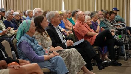 Asm. Bennett (center) seated next to Office Assistant Taylor Spira (left) among audience members listening to guest speaker.