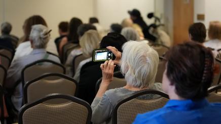 Attendee capturing photo of powerpoint slide.