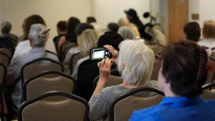 Attendee capturing photo of powerpoint slide.