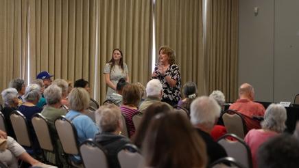 Attendee speaking to Senior Scam Stopper audience.