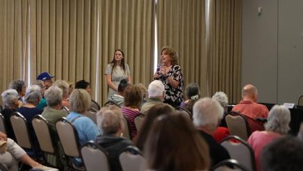 Attendee speaking to Senior Scam Stopper audience.