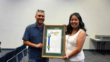 Community Action of Ventura County poses with their framed Nonprofit of the Year Resolution from Assemblymember Steve Bennett. Gabe Teran, board member (left). Susy Lopez, Executive Director (right).