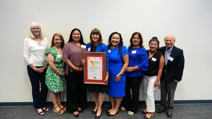 Westminster Free Clinic poses with their framed Nonprofit of the Year Resolution from Senator Monique Limón. Lisa Safaeinili, Executive Director (middle) carries the Resolution.