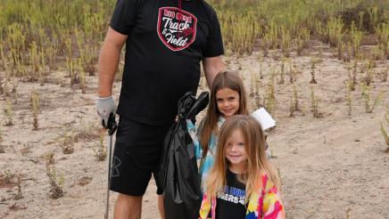 Father poses with children after picking up trash 