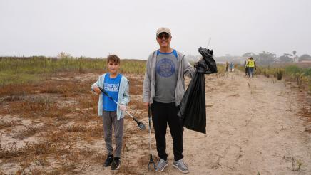 Father poses with child after picking up trash